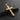 24k gold plated sterling silver cross pendant with a realistic wood texture, angled on a piece of dark, rugged stone.