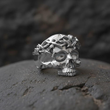 Side profile of solid silver skull ring with intricate crown of thorns texture and dark oxidized antique finish