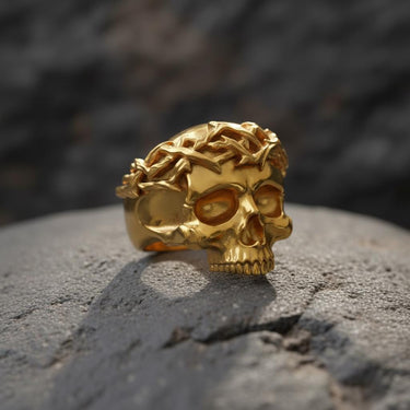 Front view of luxurious 14K gold vermeil skull ring with detailed crown of thorns design on textured stone background
