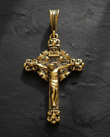Close-up view of ornate silver crucifix pendant displaying intricate floral motifs and religious craftsmanship