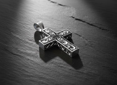 Side angle view of handcrafted cross pendant showing dimensional filigree scrollwork and oxidized silver finish