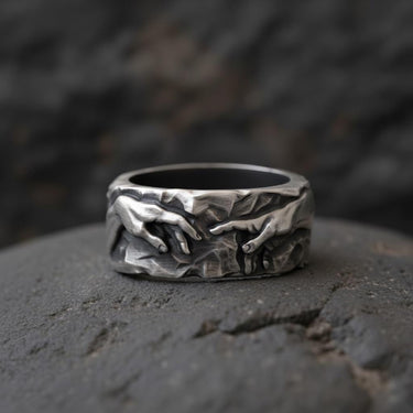 Close-up of touching hands sculpture on sterling silver Renaissance ring with gothic black rhodium coating
