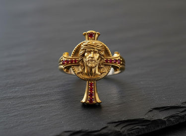 Gold vermeil Jesus cross ring with red gemstones and crown of thorns detail on black background