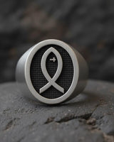 925 sterling silver Christian fish ring with black rhodium Ichthys symbol on textured background displayed on stone