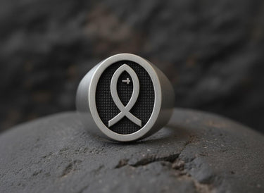925 sterling silver Christian fish ring with black rhodium Ichthys symbol on textured background displayed on stone