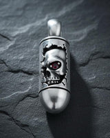 Close-up view of silver skull pendant with ruby red eye accent and bullet-shaped body design