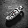925 sterling silver skull bullet pendant with red gemstone eye on dark textured stone background