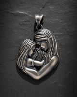 925 sterling silver mother child pendant showing tender embrace with flowing hair details on dark slate background