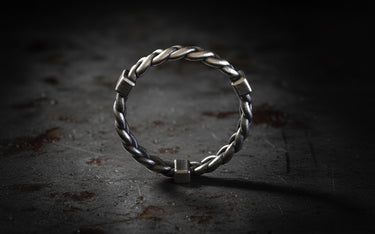 Side profile view of sterling silver twisted rope ring showing open adjustable band and intricate braided metalwork detail