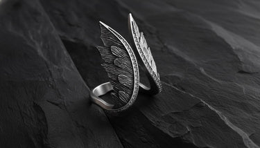 925 sterling silver angel wings ring with sparkling cubic zirconia gems displayed on dark slate background