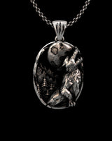 Handcrafted wolf moon pendant in 925 silver. Angled view showing the wolf's textured fur and the unique claw mark bail.
