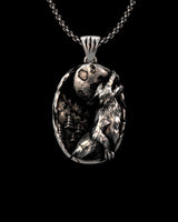 Silver wolf pendant featuring a 3D howling wolf and full moon, with an oxidized finish on a chain against a black background.