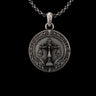 High-detail front view of the sterling silver Scales of Justice pendant, showcasing its ornate Victorian filigree border on a black background.