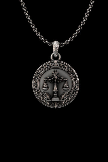 High-detail front view of the sterling silver Scales of Justice pendant, showcasing its ornate Victorian filigree border on a black background.