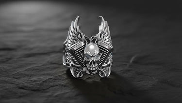925 sterling silver winged skull ring with engine details and oxidized finish displayed on dark wooden surface