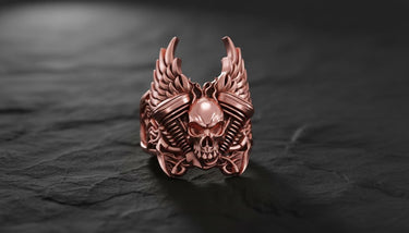 Side angle view of handcrafted sterling silver biker skull ring showing detailed wing feathers and mechanical elements