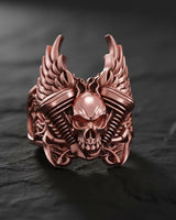 Rose gold colored skull engine ring featuring motorcycle-inspired design with spread wings and detailed metalwork