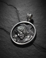 925 sterling silver Jesus carrying cross pendant with detailed relief sculpture on dark slate background