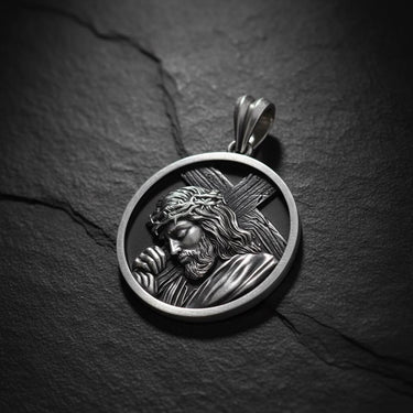 925 sterling silver Jesus carrying cross pendant with detailed relief sculpture on dark slate background