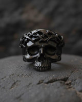 Side angle view of gothic crown of thorns skull ring showing detailed metalwork and oxidized silver finish on textured background