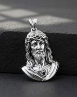 Close-up view of handcrafted Jesus pendant displaying sacred heart and flowing hair religious symbolism