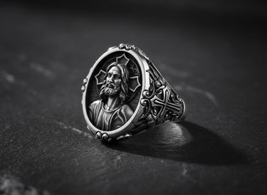 Side angle view of oxidized silver Jesus signet ring showing ornate Gothic border details and band thickness