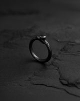Dark oxidized 925 sterling silver Ouroboros ring featuring detailed snake scales on textured black background