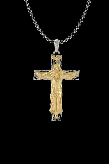 Handmade silver crucifix pendant with a gold vermeil Jesus figure on a textured cross, shown on a sterling silver chain.