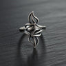 Oxidized Silver Leaf Ring with an intricate openwork design of four leaves, resting on a dark, textured slate surface.