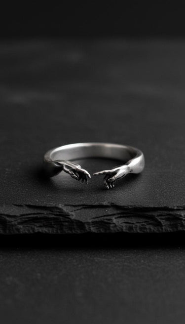 925 Sterling Silver Creation of Adam Ring with a detailed oxidized finish, resting on a dark, textured slate surface.