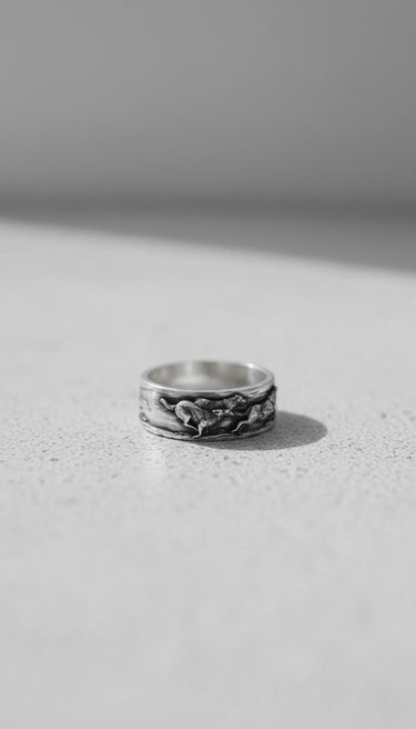 Oxidized 925 sterling Silver Wolf Ring band featuring a continuous wilderness design, shot on a clean, light surface.