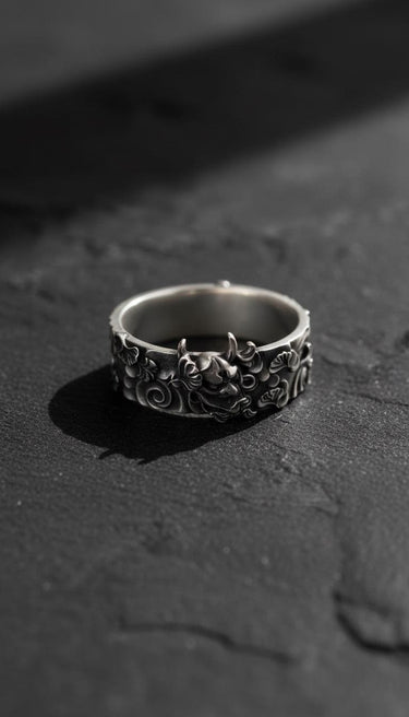 Oxidized sterling silver Hannya mask ring showing the detailed demonic face and horns on a dark slate background.