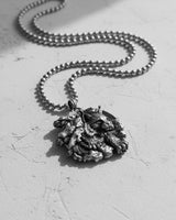 Artisan-crafted silver lynx pendant for men, angled view in black and white highlighting the 3D relief of the design.