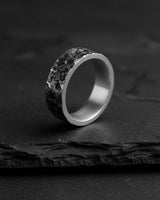 Oxidized Moon Surface Silver Ring shown at an angle on a dark slate surface, highlighting the deep texture and smooth interior.