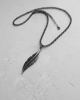 Handcrafted 925 sterling silver feather pendant necklace with an oxidized finish, displayed in full on a neutral surface.