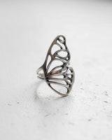 Angled view of the 925 sterling silver butterfly wing ring, highlighting the double band and the ethereal, skeletal wing structure.