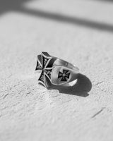 Side profile of the Silver Maltese Cross Ring displaying the engraved cross detail on the shank, with a dramatic shadow.