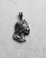 Silver Queen Pendant with an oxidized finish showing detailed hair texture, viewed from a slight angle on a gray surface.