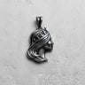 Silver Queen Pendant with an oxidized finish showing detailed hair texture, viewed from a slight angle on a gray surface.