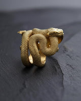 Angled side view of the sterling silver snake ring on a dark surface, showcasing the layered coils that form the band.