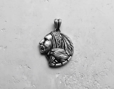 Oxidized Silver Indian Chief Pendant showing intricate feather and eagle details on a light grey textured surface.
