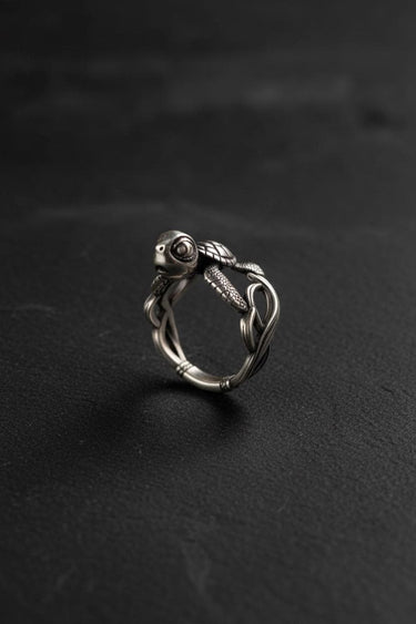 Silver Turtle Ring with a detailed, small turtle on a woven band, shown against a dark, textured slate background.