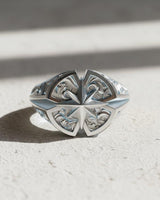 Handcrafted North Star signet ring in 925 silver showing its detailed face and polished band in bright light on a white surface.