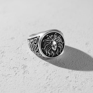 Angled side view of the silver Medusa ring, showing the detailed Gorgon face and the intricate Celtic-style knotwork on the band.