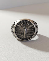 Front view of the sterling silver Libra ring showcasing the detailed Lady Justice figure and balanced scales on a white surface.