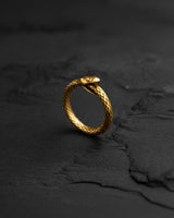 Close-up of 14k gold vermeil Ouroboros ring with textured snake scales on dark background