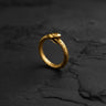 Close-up of 14k gold vermeil Ouroboros ring with textured snake scales on dark background