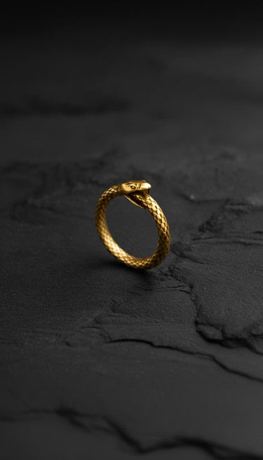 Close-up of 14k gold vermeil Ouroboros ring with textured snake scales on dark background