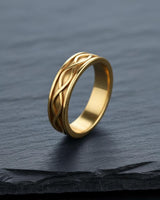 14K gold vermeil infinity knot ring with woven pattern on dark slate background symbolizing eternal love
