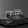 Silver Vampire Fangs Ring with an oxidized finish, showcasing the detailed teeth and sharp canines on a dark slate surface.